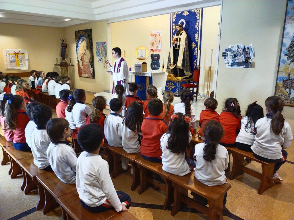 Alumnos de Infantil sentados en los bancos de la capilla del colegio durante una celebración