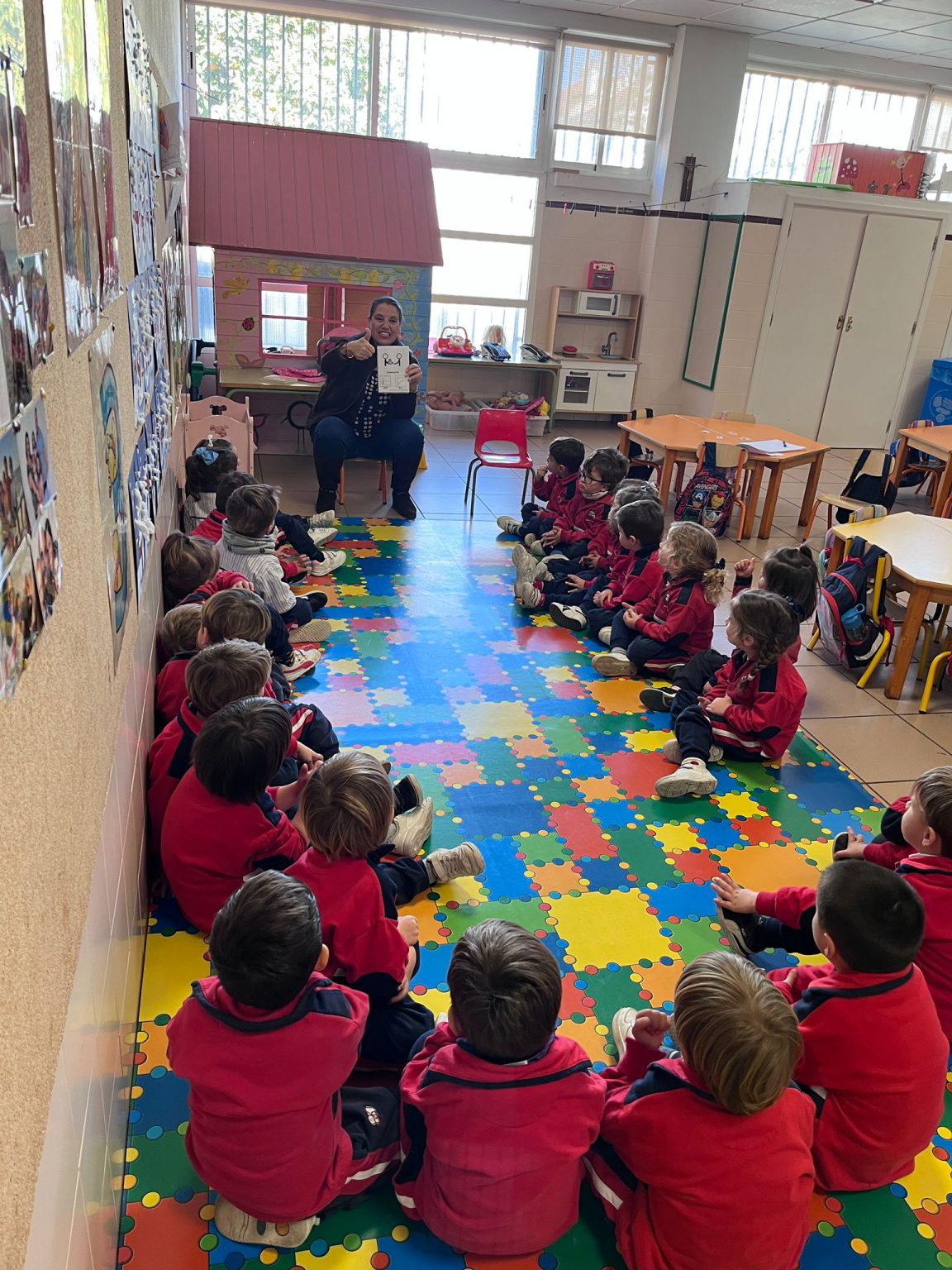 Grupo de Infantil sentado en corro sobre la alfombra de colores del aula
