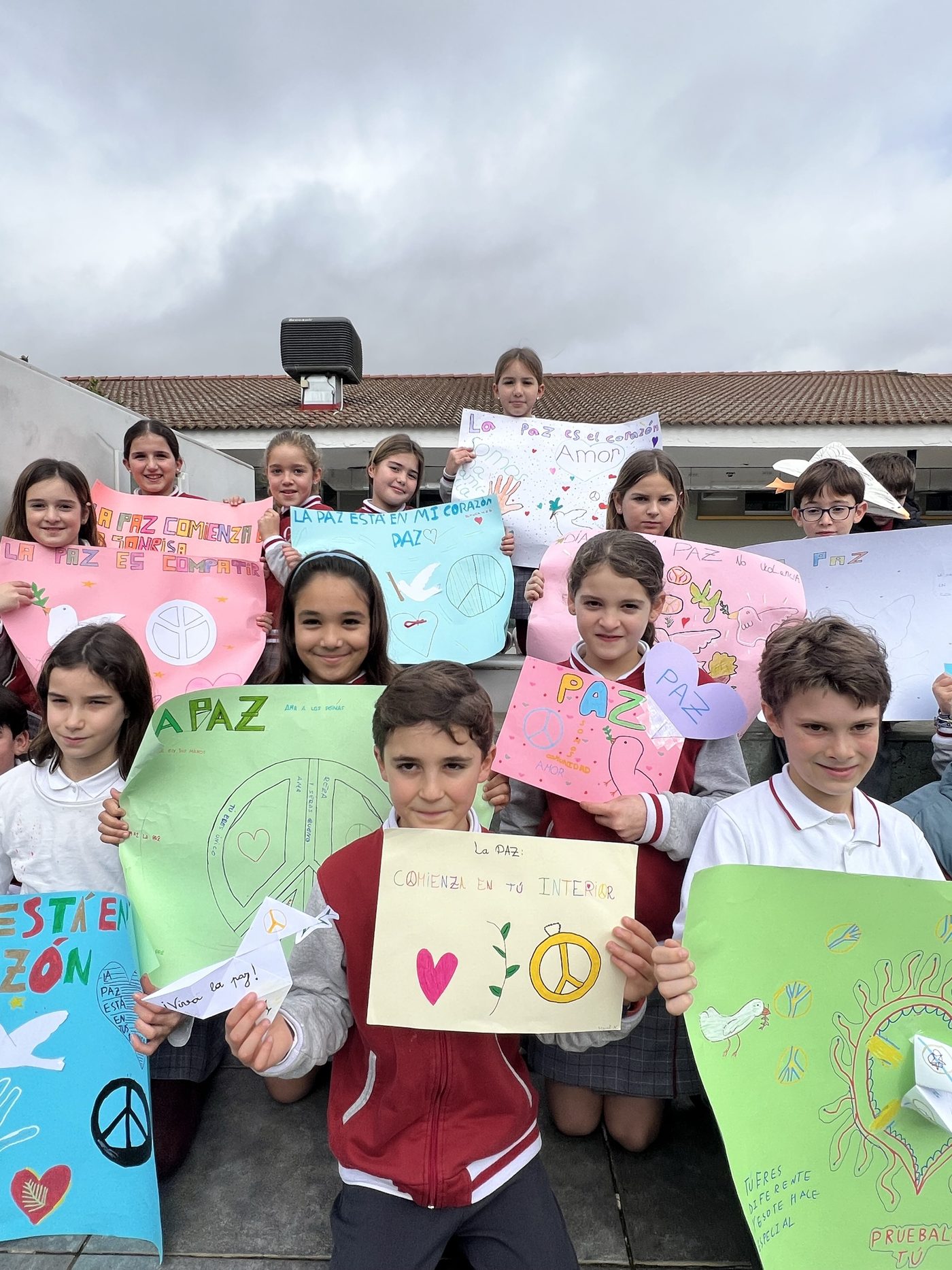 Alumnos de Primaria mostrando los carteles que han hecho para el Día de la Paz
