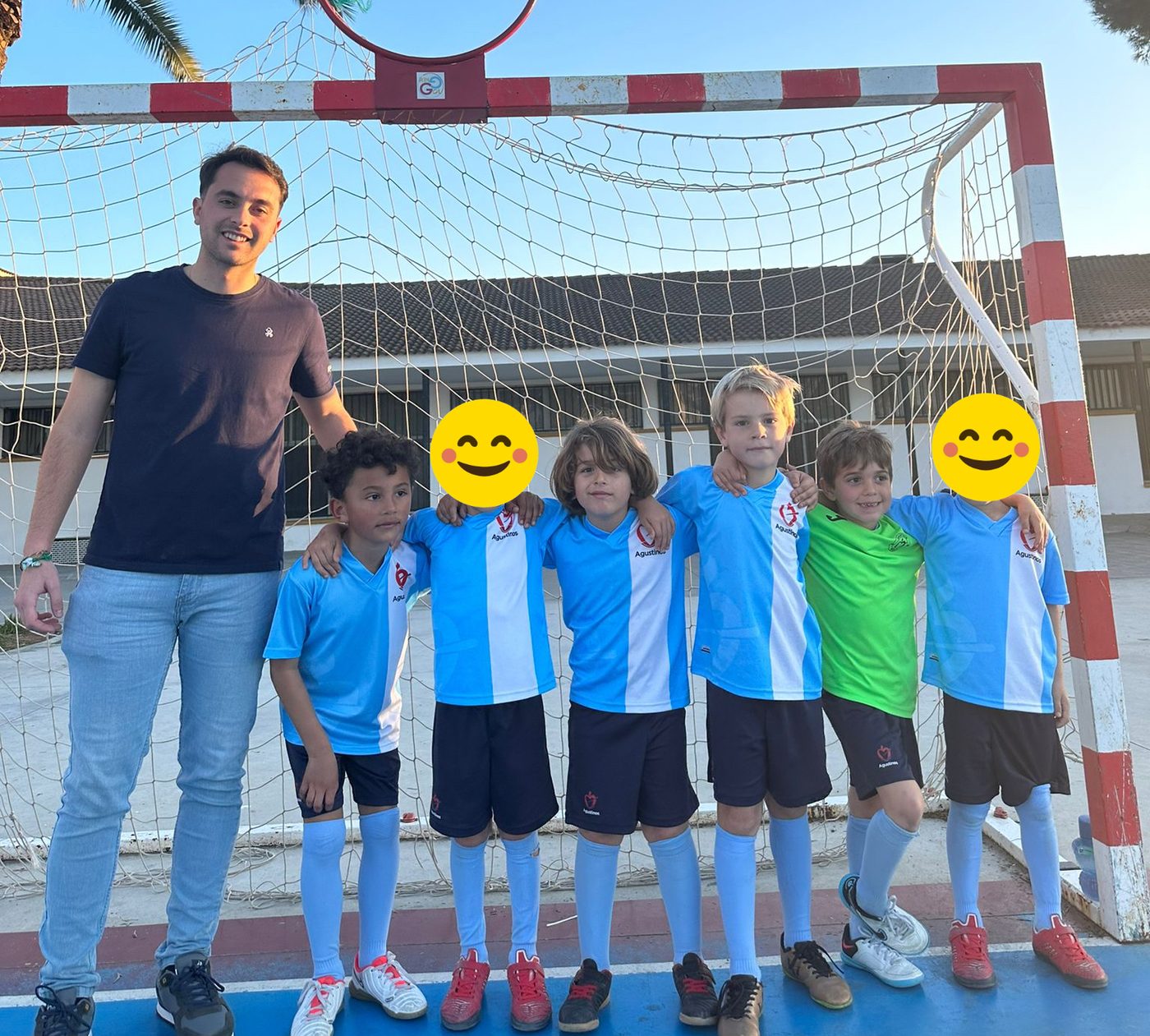 Los más pequeños del equipo de fútbol sala, con su entrenador, ante la portería