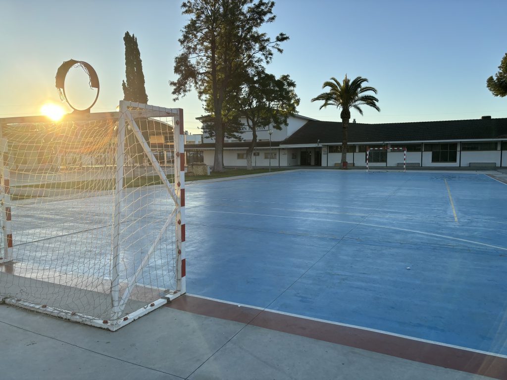 Portería de balonmano junto a la pista azul de fútbol sala, al amanecer