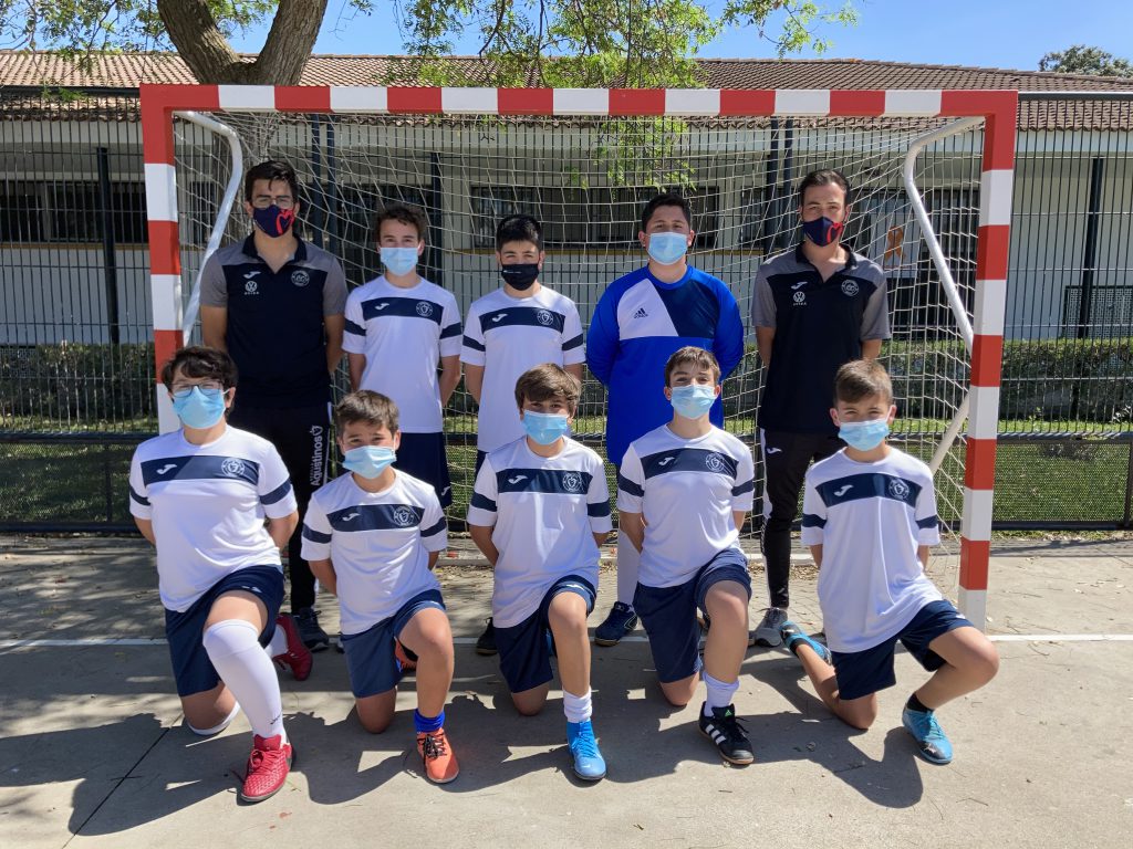 Equipo de fútbol sala del colegio con sus entrenadores, ante la portería