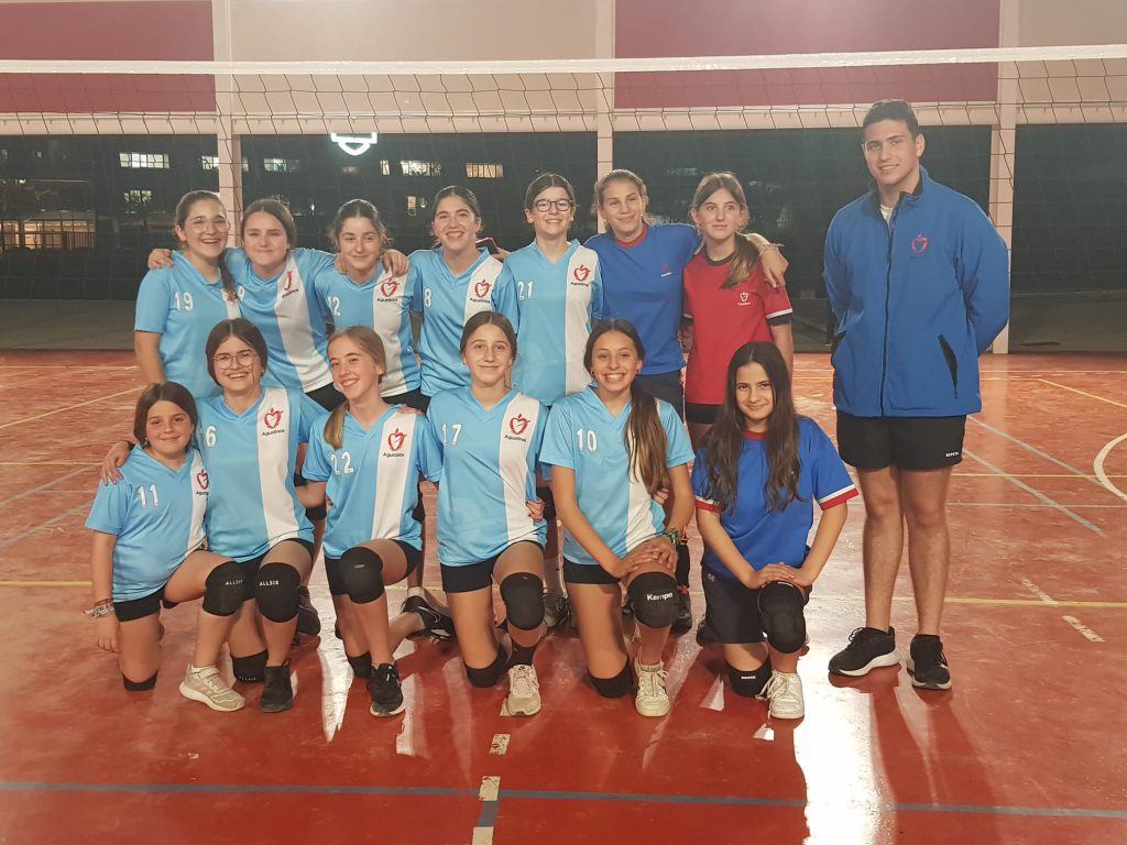 Equipo infantil de voleibol del colegio, en la pista cubierta