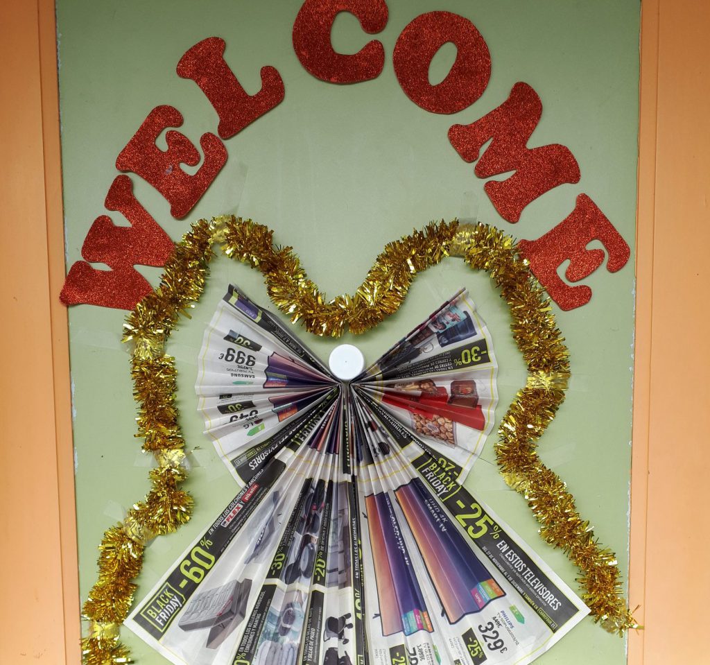 Mural de una clase con la palabra WELCOME recortada en letras rojas