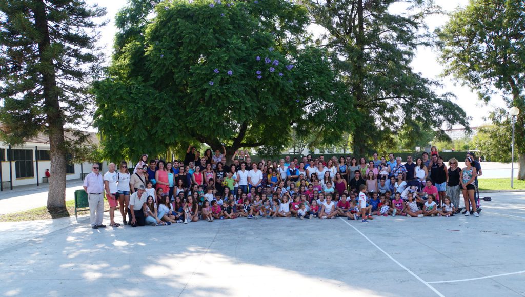 Todo el colegio posando en el patio bajo la copa de un árbol grande