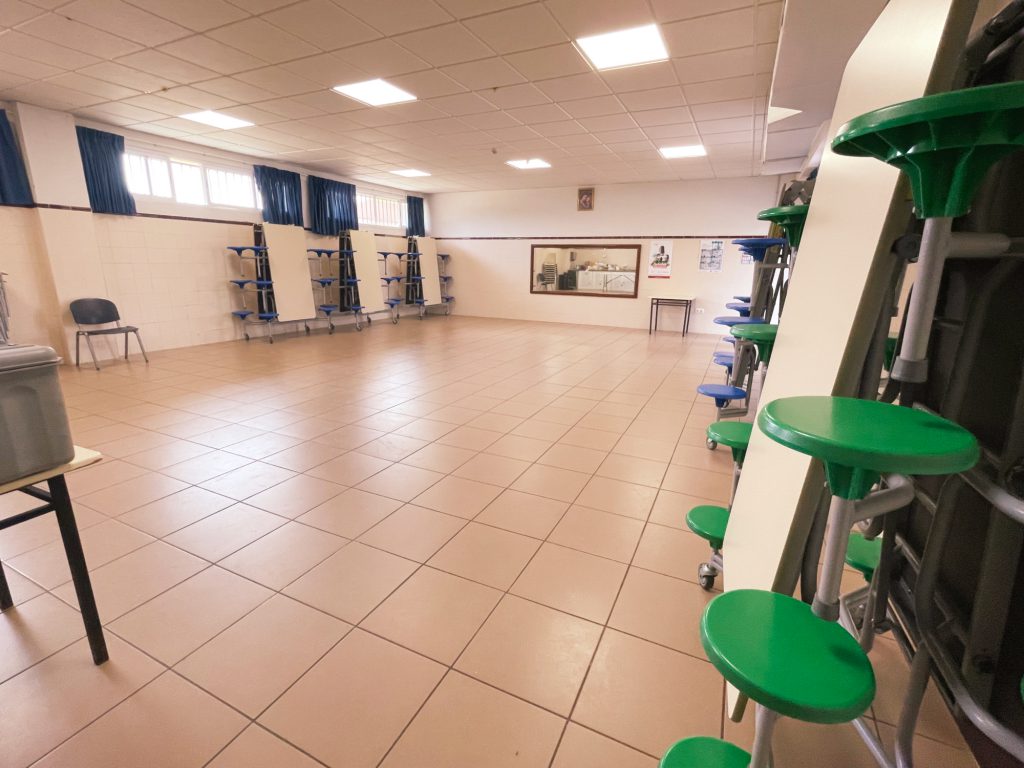 Sala diáfana con taburetes verdes recogidos contra la pared