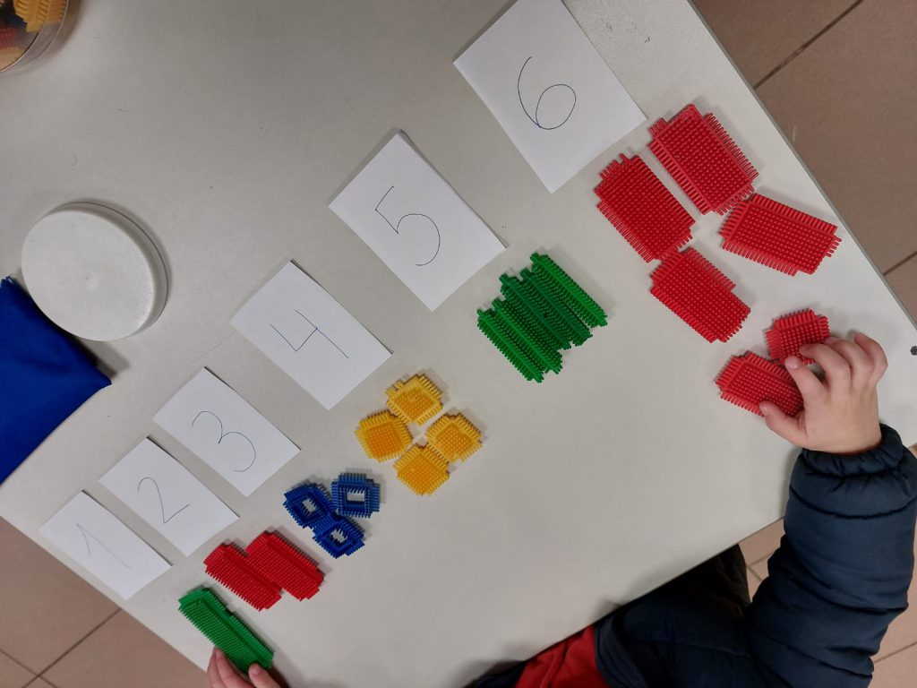Material manipulativo del método ABN: tarjetas con cifras y piezas de colores sobre una mesa