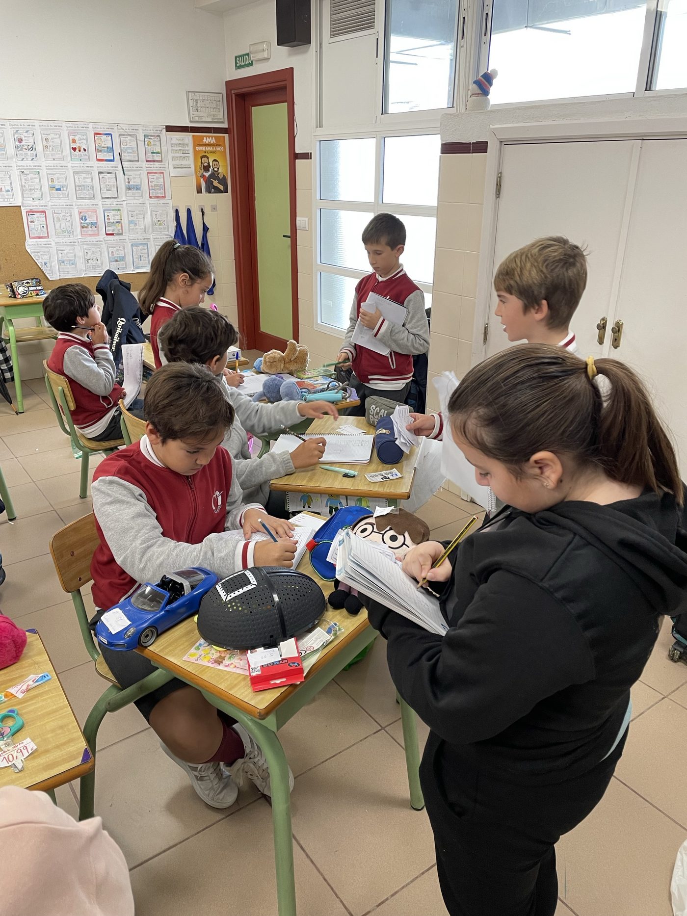 Alumnos de Primaria trabajando en grupos alrededor de las mesas del aula