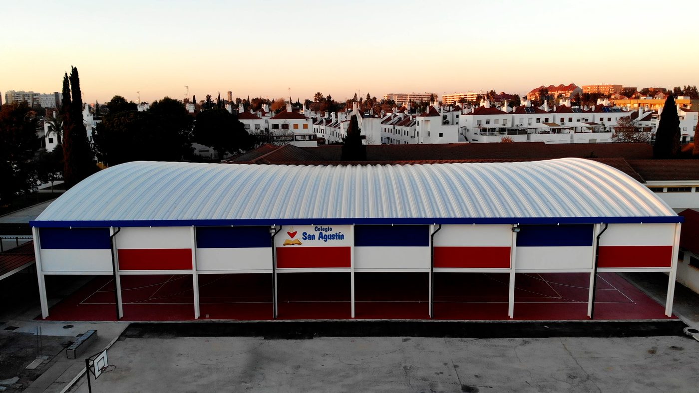 El pabellón cubierto del colegio visto desde el aire, con la luz del atardecer